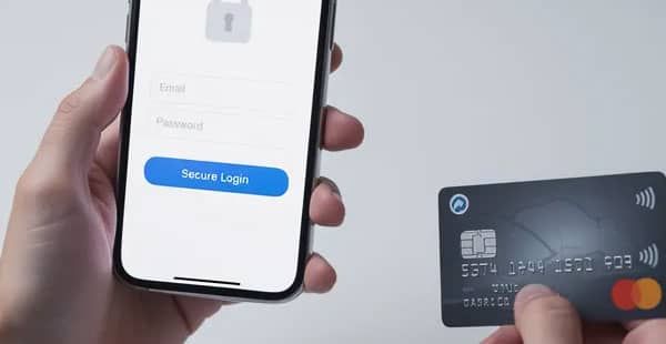 A person is holding a smartphone that displays a secure login screen, with a credit card placed nearby, suggesting they are preparing to access their online casino account for potential bonuses and promotions. The scene emphasizes the importance of security in online gambling transactions.