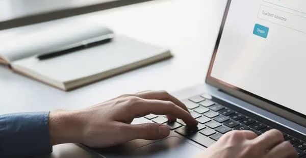 A person is sitting at a desk, focused on filling out a registration form on their laptop computer, possibly for an online casino to access various bonuses like free spins or a deposit bonus. The scene captures the essence of online gaming, where players can enjoy casino games and take advantage of promotional offers.